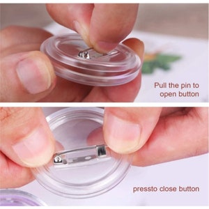 May include: Close-up of a clear plastic button with a metal pin. The pin can be pulled out to open the button and pressed in to close it.  The text "Pull the pin to open button" and "press to close button" is visible in the image.