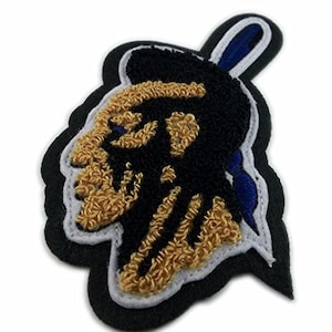 May include: A black and gold embroidered patch featuring a stylised image of a Native American chief's head. The patch has a blue and white border.