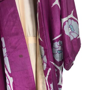 May include: A purple silk kimono with a white floral pattern. The kimono has a light beige lining.