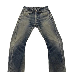 Puede incluir: Vaqueros de mezclilla azul descolorido con un ligero corte de bota. Los vaqueros tienen un dise&ntilde;o cl&aacute;sico de cinco bolsillos, cierre de bot&oacute;n y cremallera, y un lavado descolorido para una apariencia desgastada. El texto "--FUNCTION--" est&aacute; en la cintura.