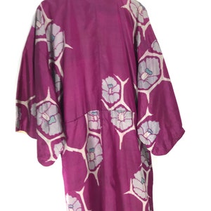 May include: A long, purple silk robe with a floral pattern. The robe has a traditional Japanese style with wide sleeves and a collar.