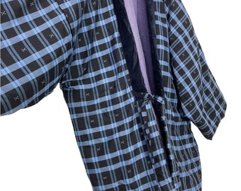 Puede incluir: Un kimono a cuadros azules y negros con un cuello de terciopelo azul marino. El kimono tiene un cierre de corbata en la cintura.