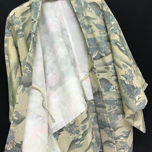 May include: A beige and blue patterned Japanese kimono with a white lining. The kimono is hanging on a hanger with the label "AKAGAMI" visible.