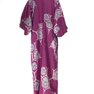 May include: A long, purple silk kimono with a floral pattern. The flowers are white with a light blue center and are arranged in a repeating pattern.