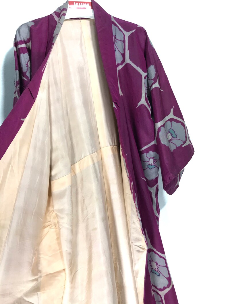 May include: A purple and gray silk kimono with a floral pattern. The kimono is open to reveal the cream-colored lining.