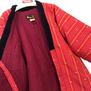 Op de afbeelding: Rode en witte gestreepte Japanse kimono met zwarte fluwelen bies. De kimono heeft een rode voering en een label met de tekst "Akagami" in het Japans.