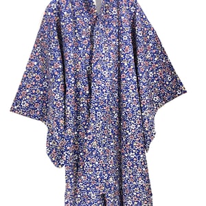 May include: A blue kimono with a floral pattern in shades of pink, white, and yellow. The kimono is hanging on a hanger.
