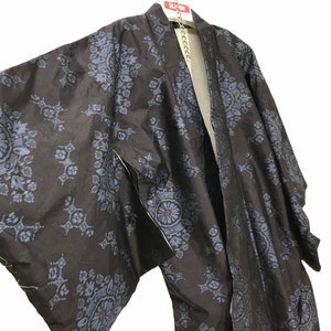 Może przedstawiać: Czarny i niebieski kimono z tradycyjnym japońskim wzorem. Kimono wisi na wieszaku.