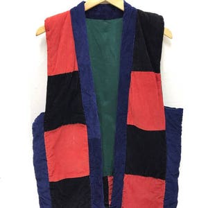 Puede incluir: Un chaleco de patchwork con un esquema de color azul, rojo y negro. El chaleco está hecho de pana y tiene un forro verde.