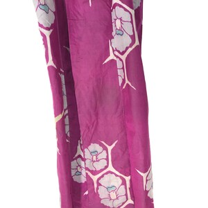 May include: A purple silk kimono with a white floral pattern. The kimono has a light blue accent color in the flowers.