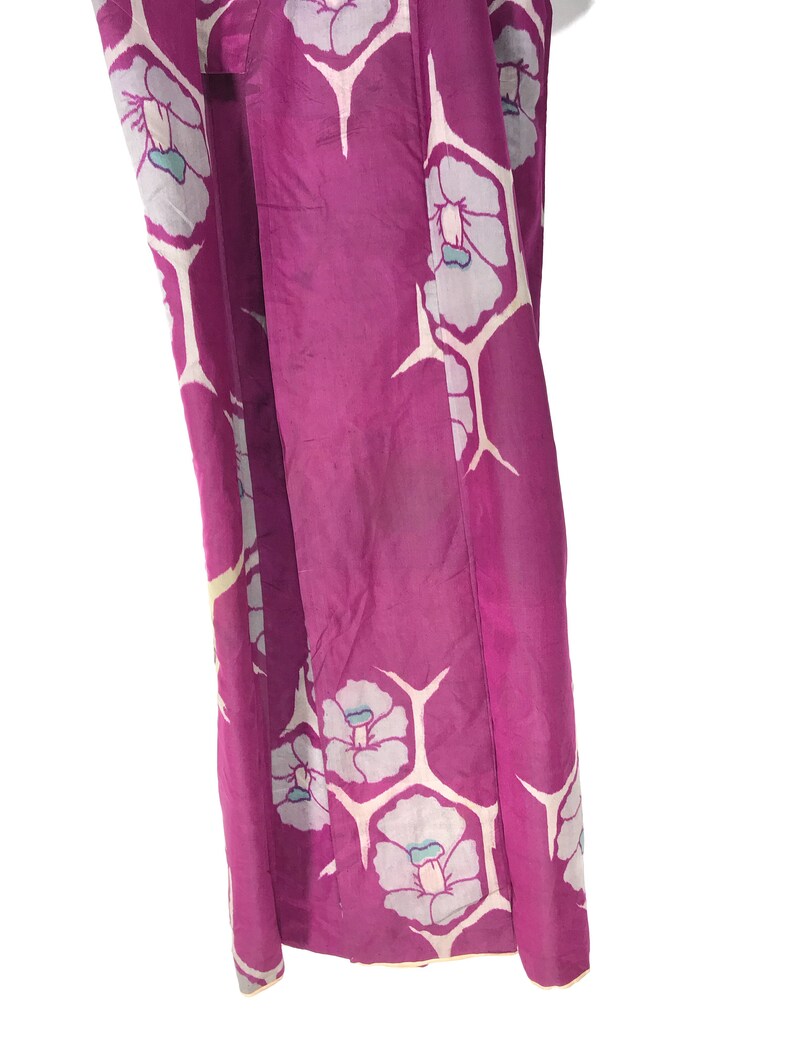 May include: A purple silk kimono with a white floral pattern. The kimono has a light blue accent color in the flowers.