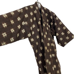 May include: A brown and white patterned kimono robe with a long sleeve design.
