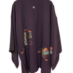 May include: A dark purple silk kimono with a traditional Japanese design featuring colorful geometric patterns and orange accents.