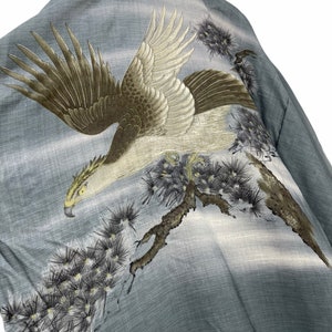 May include: A blue and gray silk kimono with an embroidered image of a white eagle with brown wings perched on a branch of a pine tree.