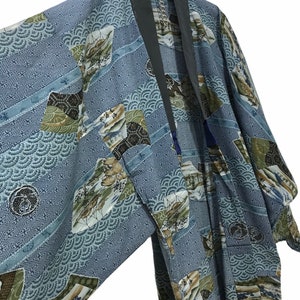 May include: A blue and green patterned kimono with a black collar. The kimono has a traditional Japanese design with a variety of geometric and floral patterns.