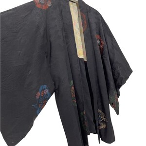 Peut inclure: Un kimono en soie noire avec des motifs floraux et géométriques colorés. Le kimono a un design japonais traditionnel et est en bon état.