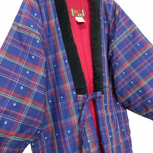 May include: A blue and red plaid kimono with a black velvet collar and a red lining. The kimono has a small white flower pattern on it. The label on the kimono says "AKAGAMI".