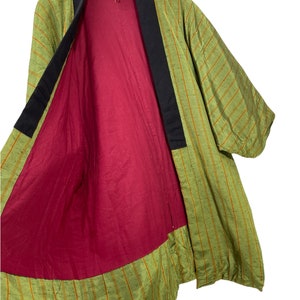 May include: A green and orange striped kimono with a red lining and black collar.