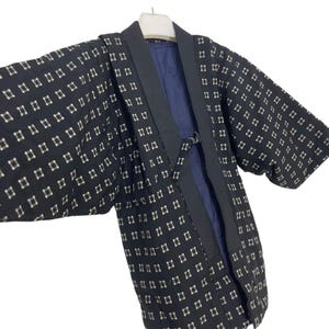 May include: A black and white patterned kimono with a navy blue collar and lining. The kimono has a geometric pattern of small squares.