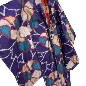 May include: A purple and blue kimono with a white and red floral pattern. The kimono is made of silk and has a traditional Japanese design.