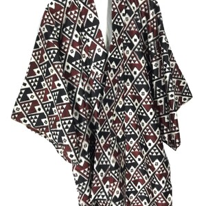 May include: A black, white, and red patterned kimono with a geometric design. The kimono has a V-neck and short sleeves.