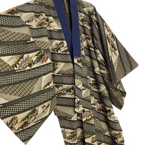 May include: A traditional Japanese kimono with a green and brown geometric pattern featuring a landscape scene. The kimono has a navy blue collar.