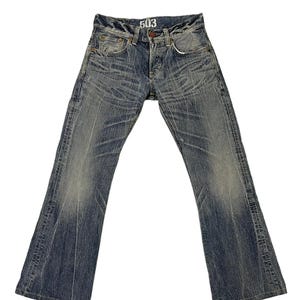 May include: Faded blue denim jeans with a flared leg design. The jeans have a button fly and classic five-pocket styling. The number "503" is printed on the front. The denim has a worn, distressed look.