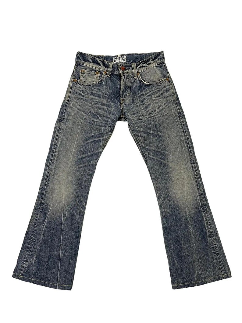 May include: Faded blue denim jeans with a flared leg design. The jeans have a button fly and classic five-pocket styling. The number "503" is printed on the front. The denim has a worn, distressed look.