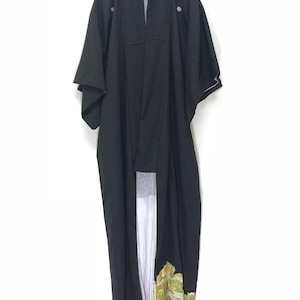 May include: A black kimono with gold and green floral embroidery. The kimono is hanging on a hanger against a white background.