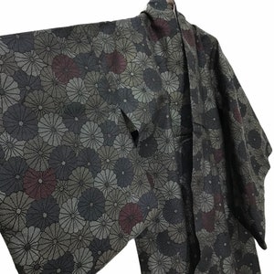 May include: A black and grey kimono with a floral pattern. The flowers are in shades of grey, black, and burgundy.