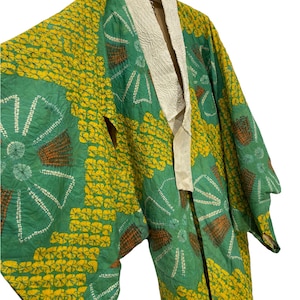 Może przedstawiać: Zielono-żółte kimono z białym kołnierzem. Kimono jest wykonane z lekkiej tkaniny i ma tradycyjny japoński wzór.