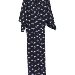 May include: A black and white patterned kimono with a geometric design. The kimono has long sleeves and a wide collar.