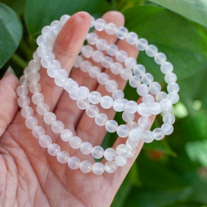 May include: A white gemstone bracelet with multiple strands of round beads. The bracelet is made of natural white stones and is a popular choice for meditation and healing.
