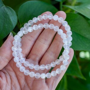 May include: White gemstone bracelet with round beads. The bracelet is made of natural stones and is perfect for everyday wear.