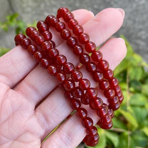 Può includere: Una collana di perle di cornalina rossa, una pietra preziosa popolare usata nella creazione di gioielli.