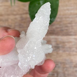 Puede incluir: Un grupo de formaciones cristalinas blancas con una superficie texturizada. Los cristales tienen una forma natural e irregular, con algunas secciones m&aacute;s puntiagudas y otras m&aacute;s redondeadas. El color general es blanco brillante y transl&uacute;cido.