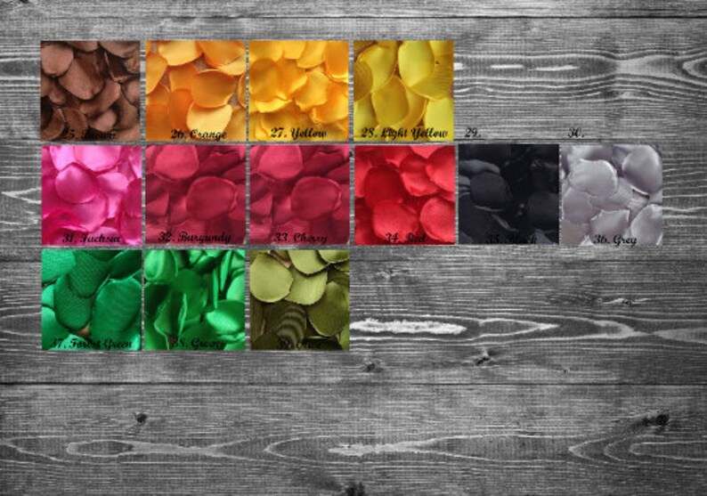 May include: Assortment of silk rose petals in various colors, including brown, orange, yellow, fuchsia, burgundy, cherry, red, black, and gray. The petals are arranged in rows on a wooden surface.