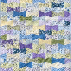 May include: A patchwork quilt with a repeating bow tie pattern. The quilt features a variety of pastel colors, including blue, purple, yellow, and green. The bow tie shapes are quilted with intricate designs, adding texture and visual interest to the handmade textile.