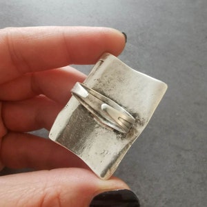 May include: A silver-toned, rectangular, hinged box with a textured surface. The box is closed and has a clasp on the top.