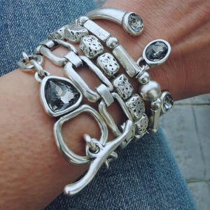 Set of 5 stacking silver plated bracelets on a woman wrist.
