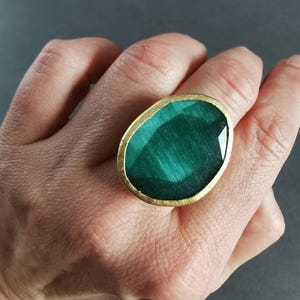 Close-up of a large emerald green cat eye stone ring