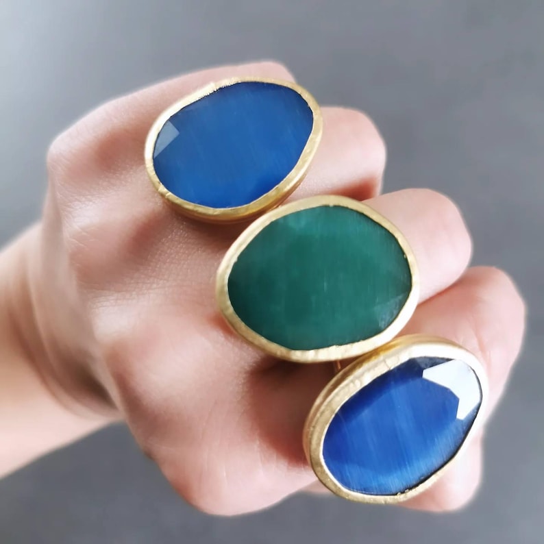 Oversized emerald green and royal blue statement ring with glossy cat eye effect