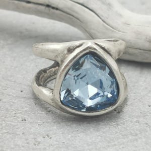 Puede incluir: Una taza de cerámica blanca con un asa negra y el texto "But First, Coffee" en negro, con una fuente de estilo manuscrito. La taza está sobre una superficie blanca.