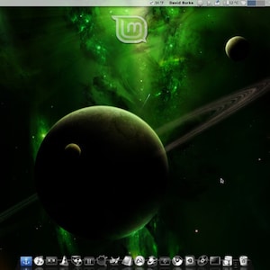 May include: A computer desktop background featuring a green and black space scene with planets, rings, and nebulae. The Linux Mint logo is in the upper center. System information is displayed on the right side.