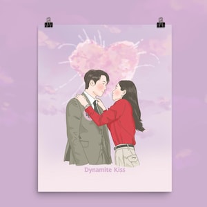 May include: A hand-drawn illustration of a couple embracing, set against a pink heart-shaped cloud background. The man wears a gray suit, and the woman is in a red shirt. The text "Dynamite Kiss" is below the couple.