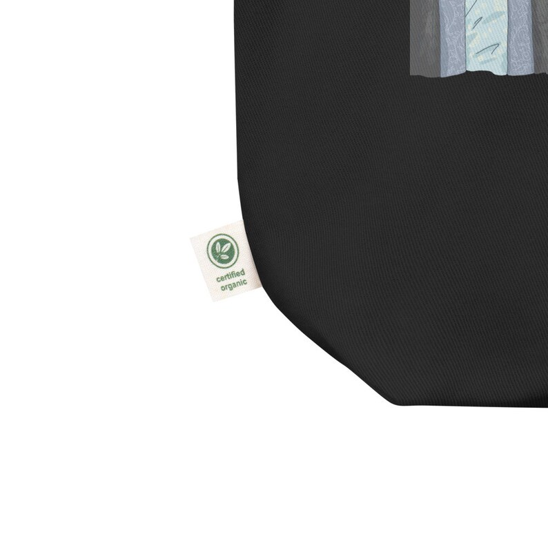 May include: Black tote bag with a green "certified organic" label. The bag has a white design on the front.