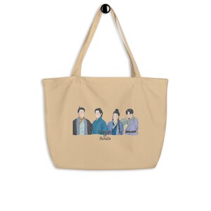 May include: A beige tote bag with a print of four people in traditional clothing. The text "Alchemy of Souls" is printed below the image.