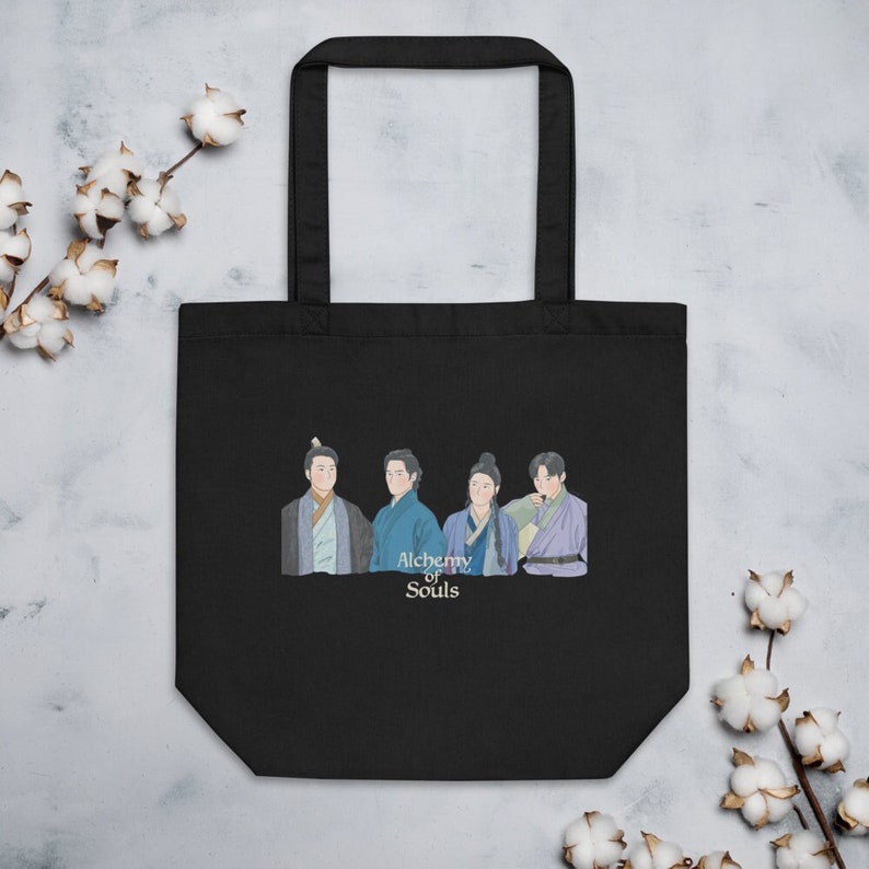 May include: Black tote bag with a white print of four people in traditional Korean clothing. The text "Alchemy of Souls" is printed below the image.