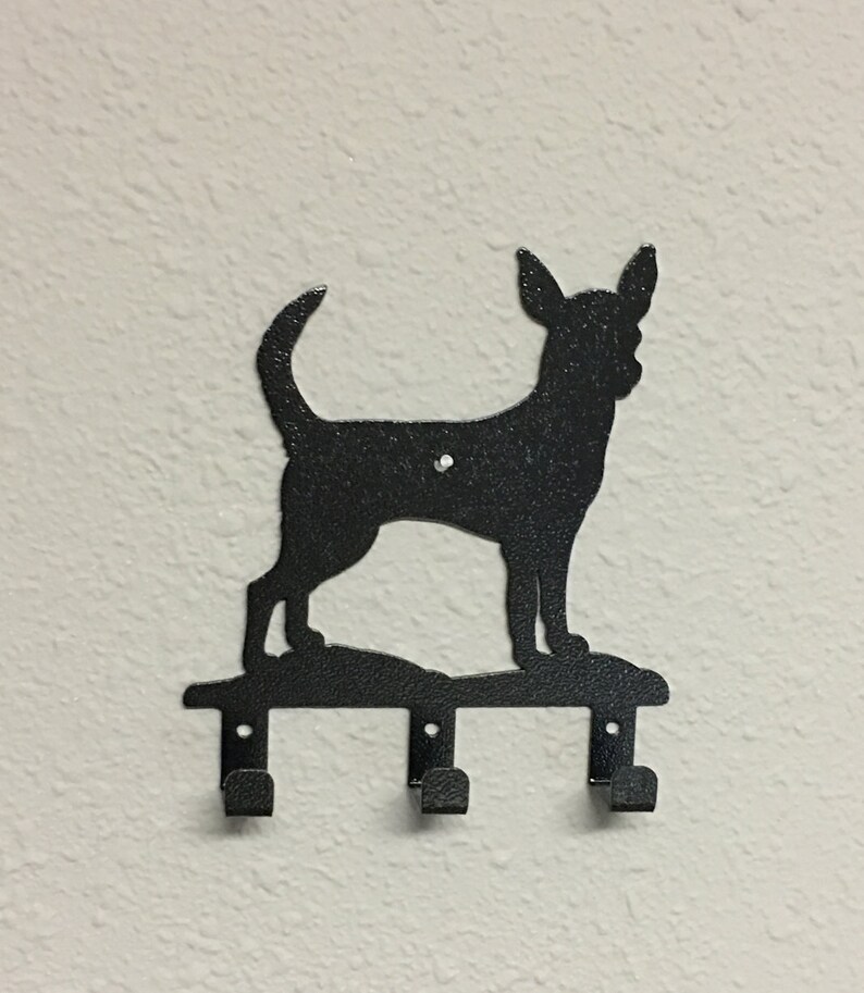 Puede incluir: Porta llaves de metal negro con forma de silueta de chihuahua con tres ganchos.