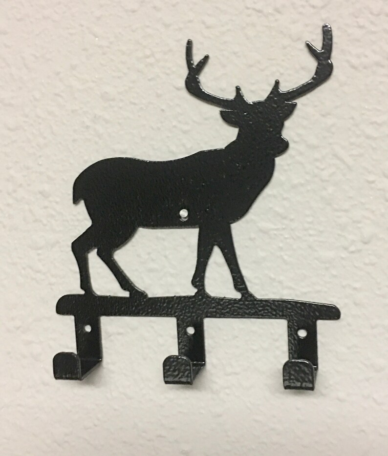 Op de afbeelding: Zwarte metalen hert silhouet wandhaak met drie haken.